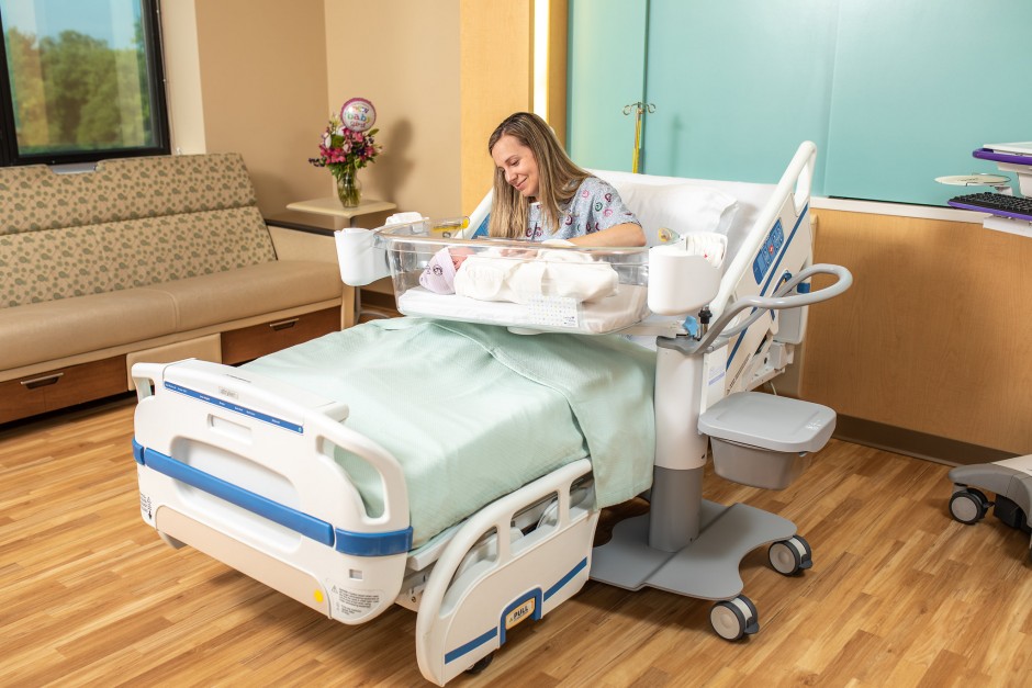 Image of woman sitting in hospital bed with baby in Halo bassinests