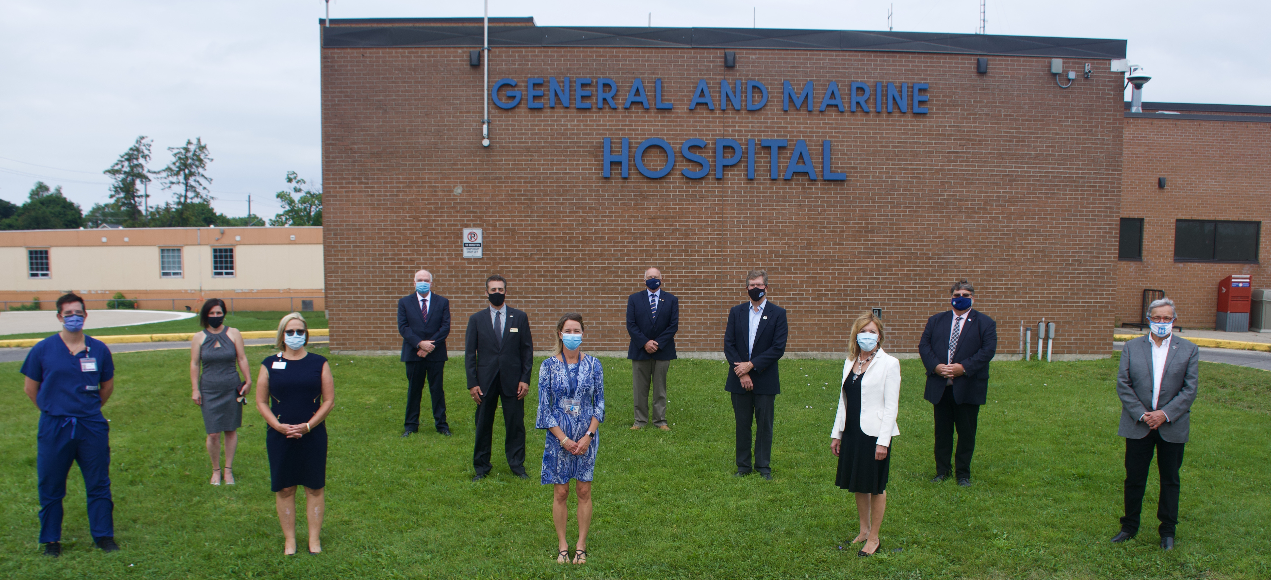 Picture of multiple South Georgian Bay mayors and council members along with senior members at CGMH, standing in front of CGMH building on grass.
